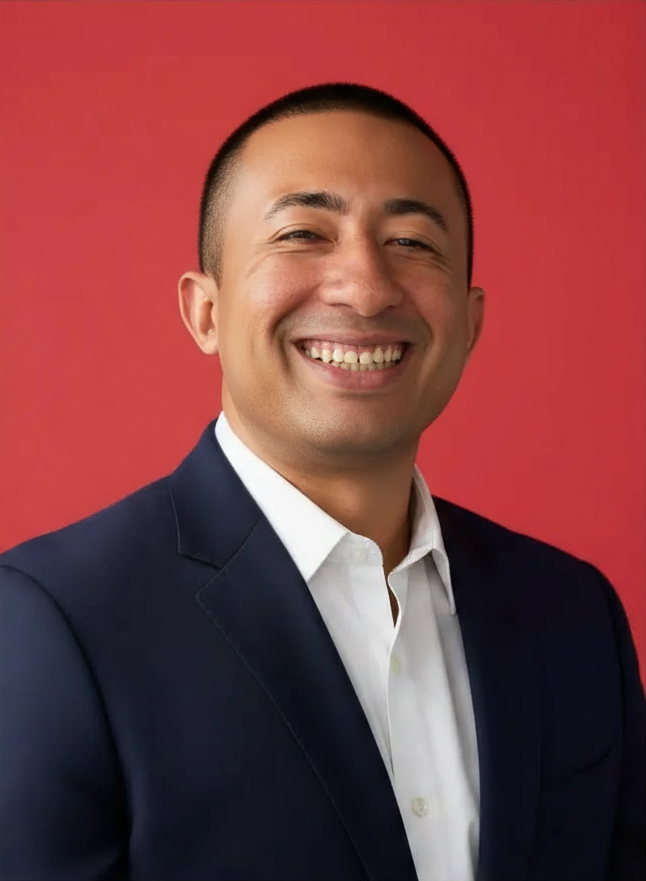 retrato-de-homem-sem-barba-rosto-bem-barbeado-e-limpo-de-terno-azul-marinho-com-fundo-na-cor-fe4f70-sorrindo-naturalmente-rosto-centralizado-estilo-profissional